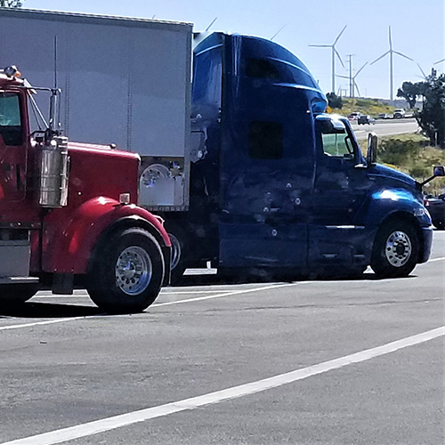 2 Semi Trucks parked in parking lot